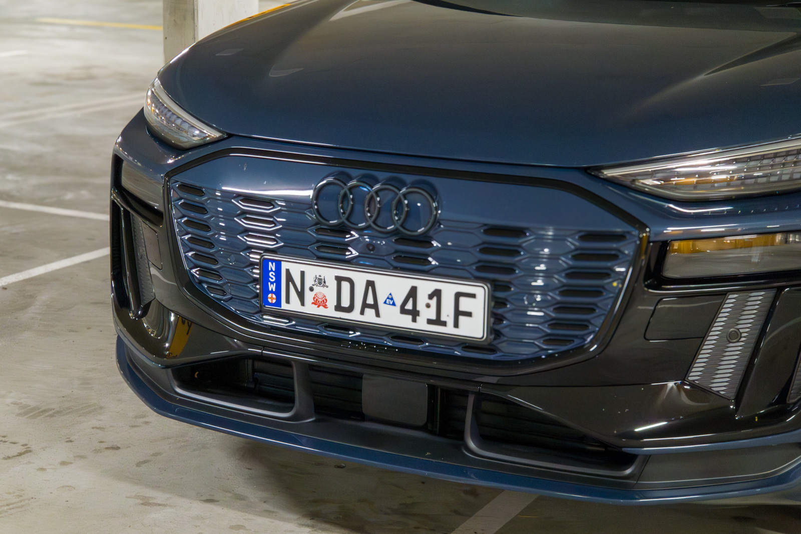 Close-up of the Audi Q6 e-tron's aerodynamic closed-off Singleframe grille design.