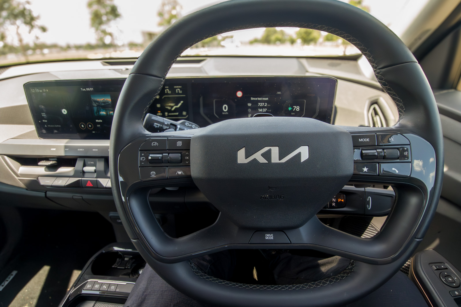 Four-spoke steering wheel of the 2025 Kia EV5 with integrated drive mode and infotainment controls.