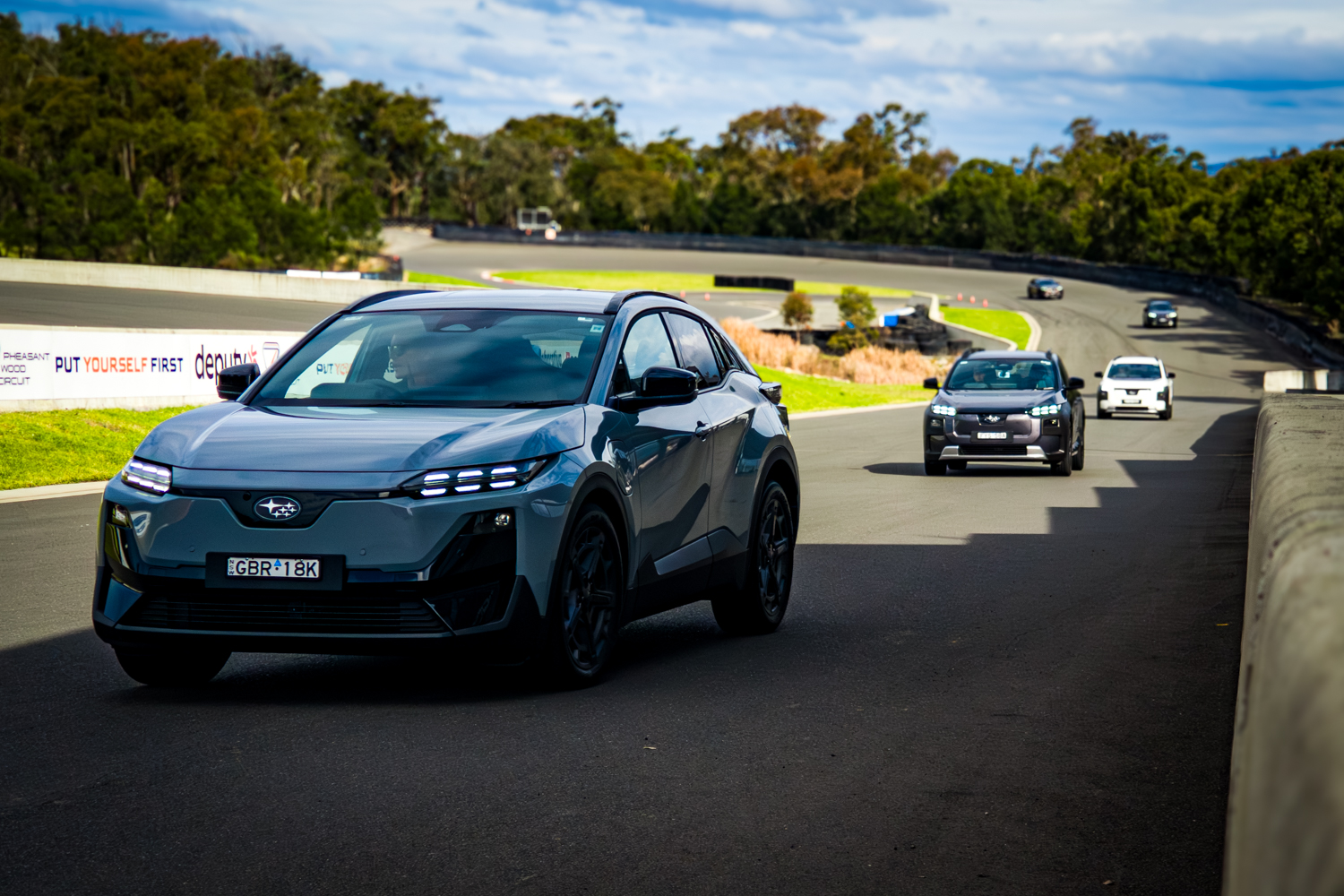 Grey 2026 Subaru Trailseeker electric SUV driving on a racetrack, front three-quarter