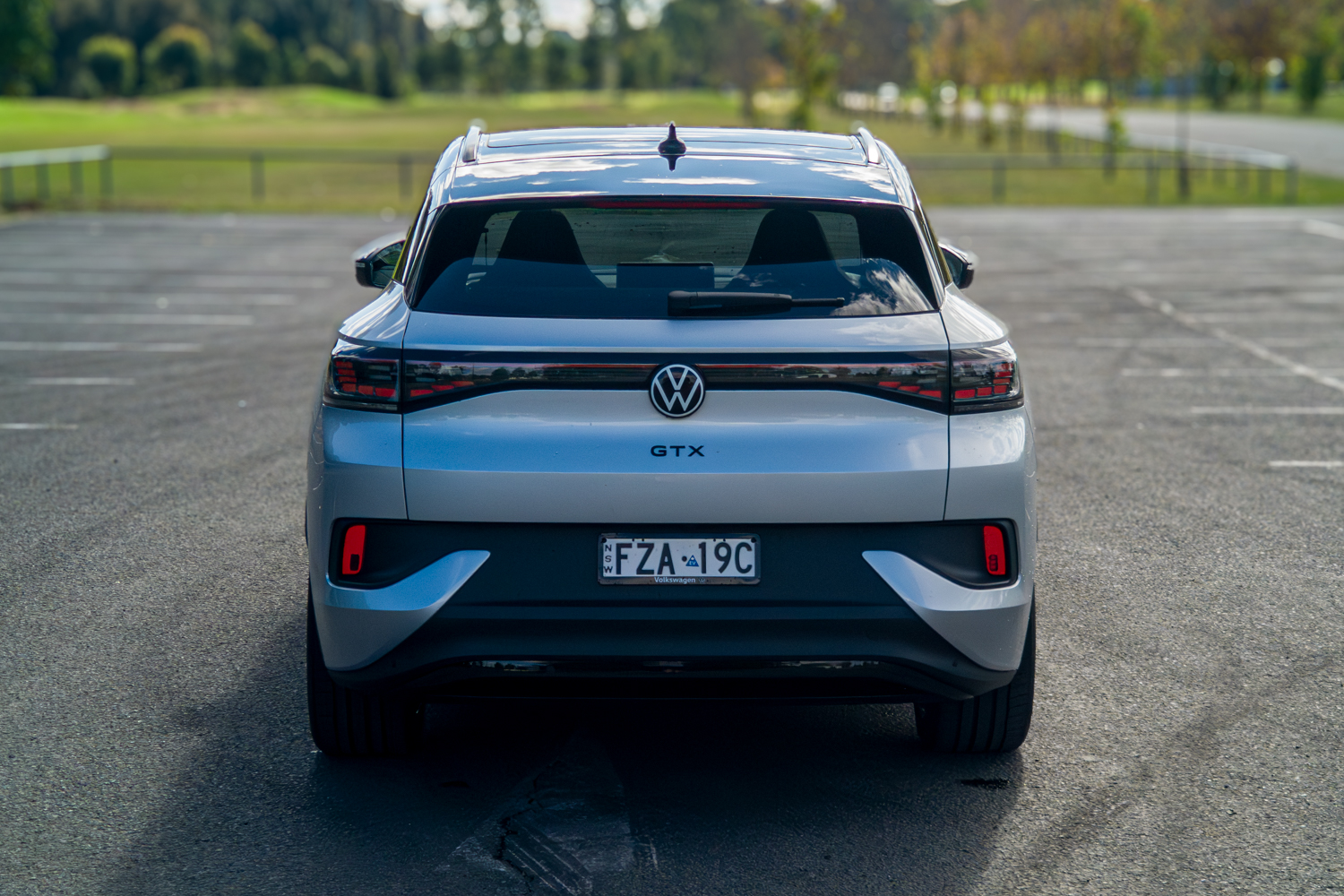 Wide straight-on rear view of the silver 2026 Volkswagen ID.4 GTX in a car park