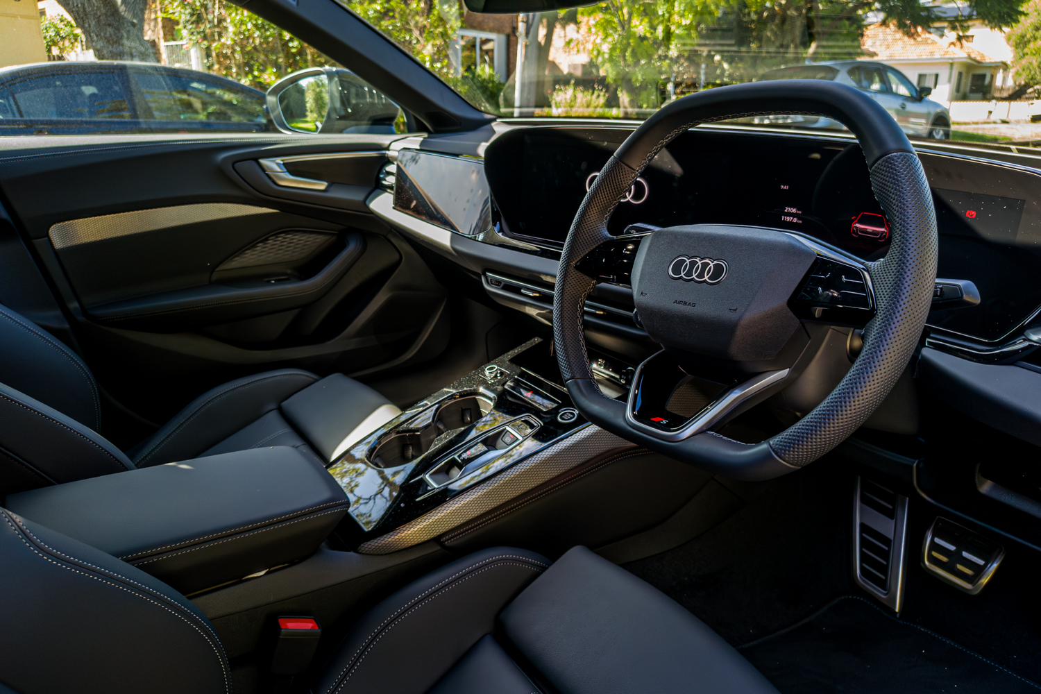 Driver cockpit of the 2026 Audi A5 Sedan e-hybrid quattro with steering wheel and marble console
