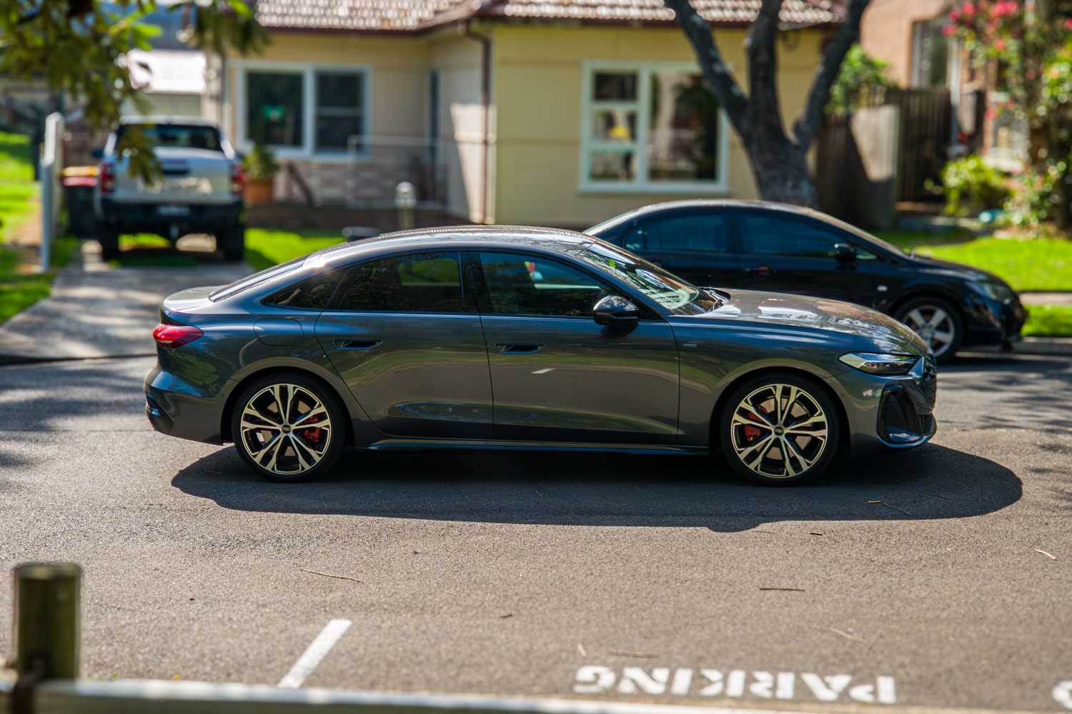 Driver-side profile of the 2026 Audi A5 Sedan e-hybrid quattro on a residential street