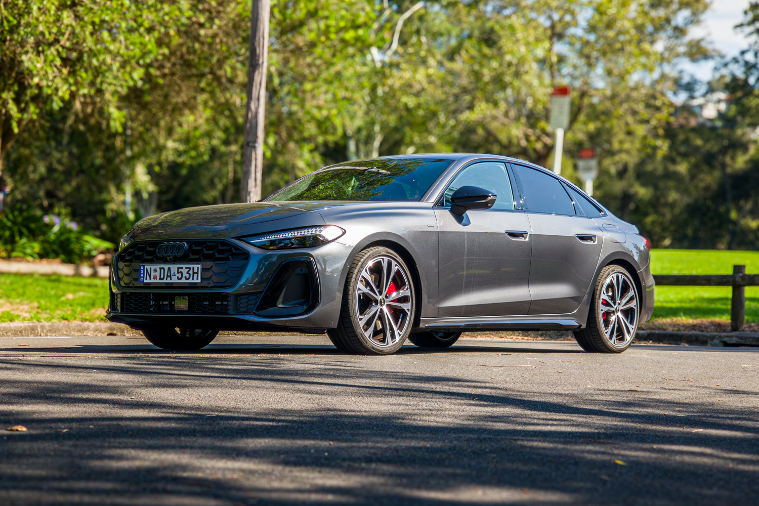 Low-angle front three-quarter of the 2026 Audi A5 Sedan e-hybrid quattro at a park