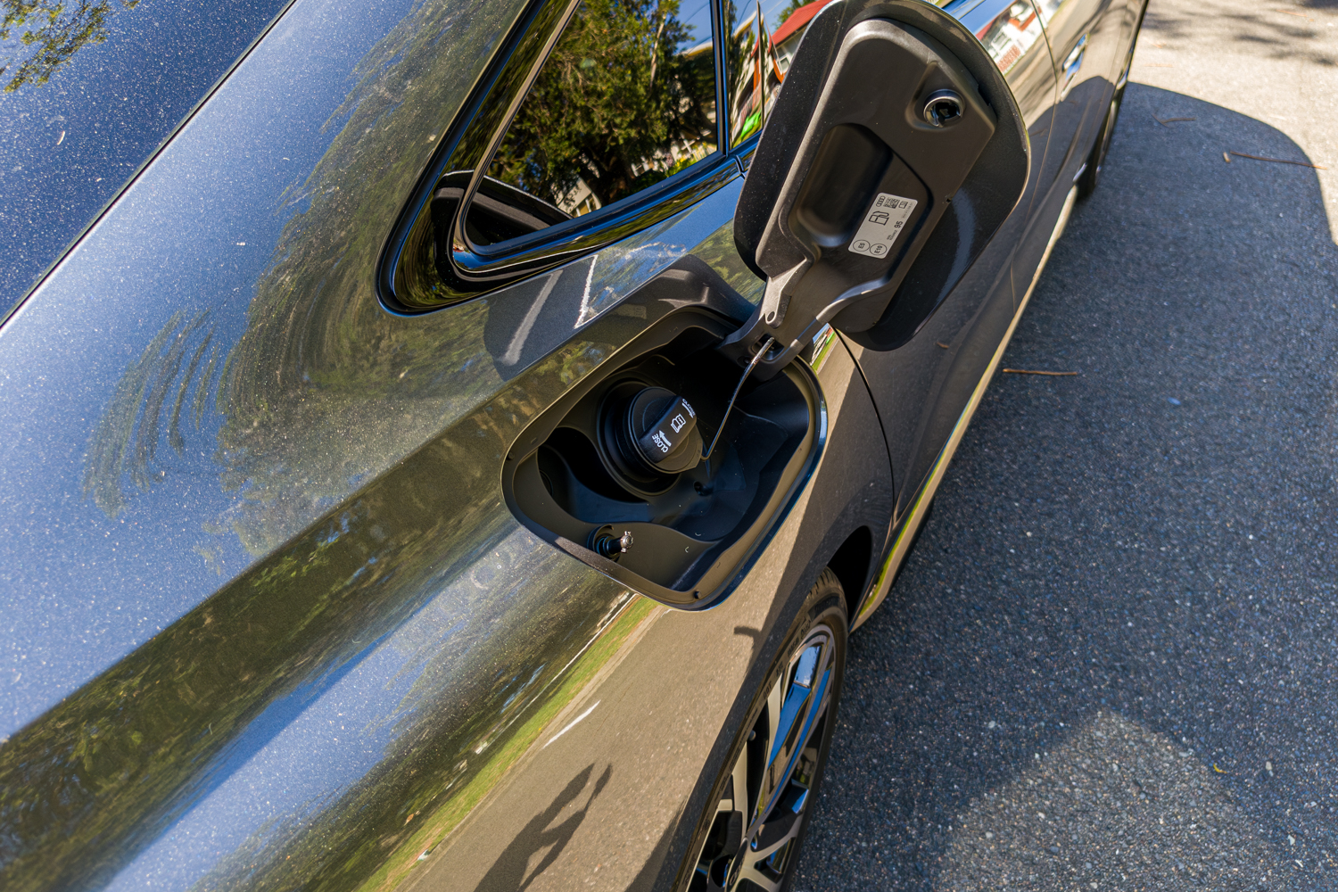 Open fuel filler flap on the 2026 Audi A5 Sedan e-hybrid quattro rear quarter