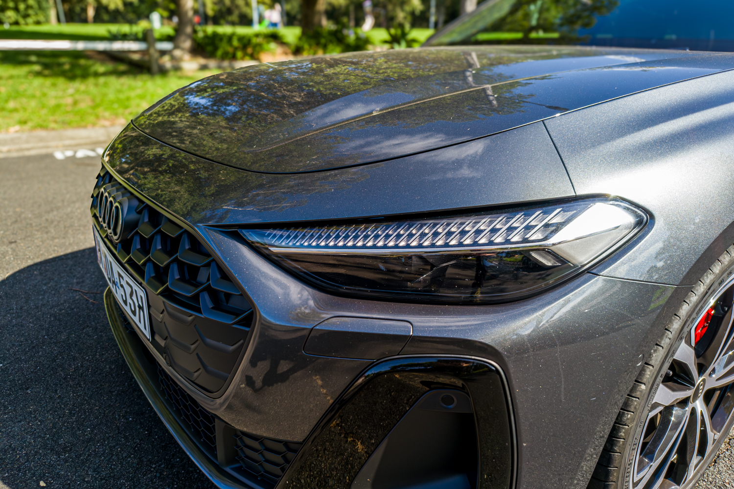 Close-up of the 2026 Audi A5 Sedan e-hybrid quattro LED headlight strip and hexagonal grille