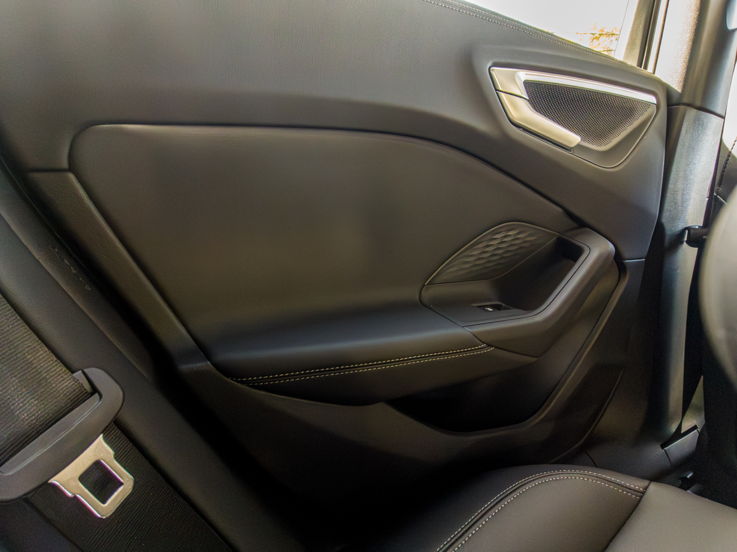 Rear door panel of the 2026 Audi A5 Sedan e-hybrid quattro showing leather and speaker grille