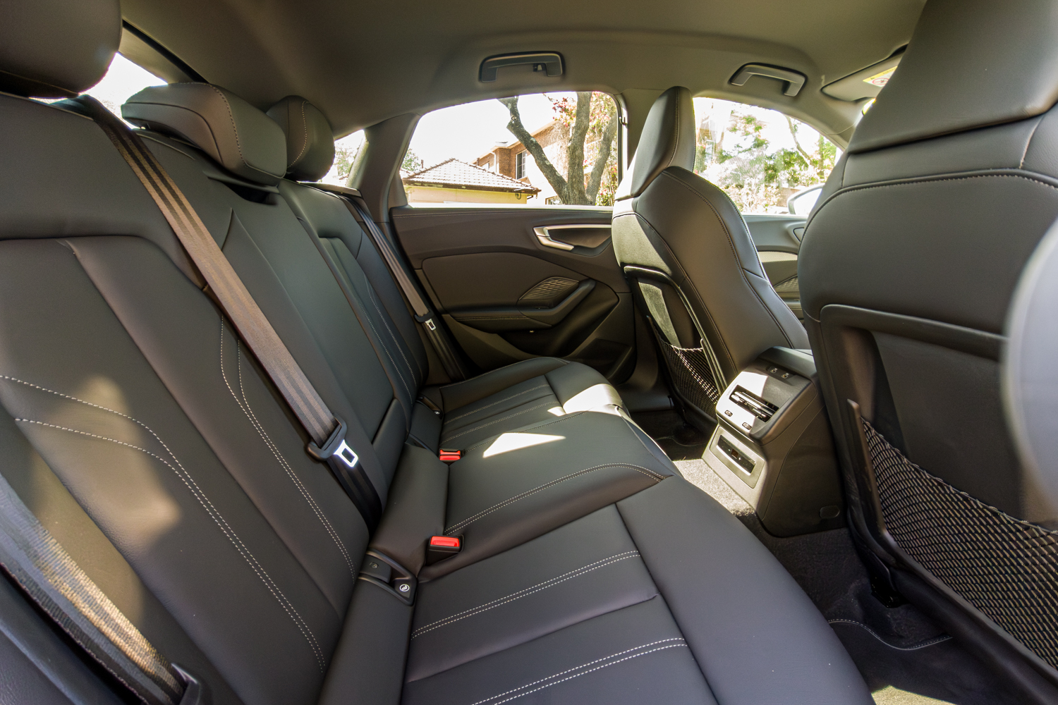 Rear passenger seats of the 2026 Audi A5 Sedan e-hybrid quattro with black leather and white stitching