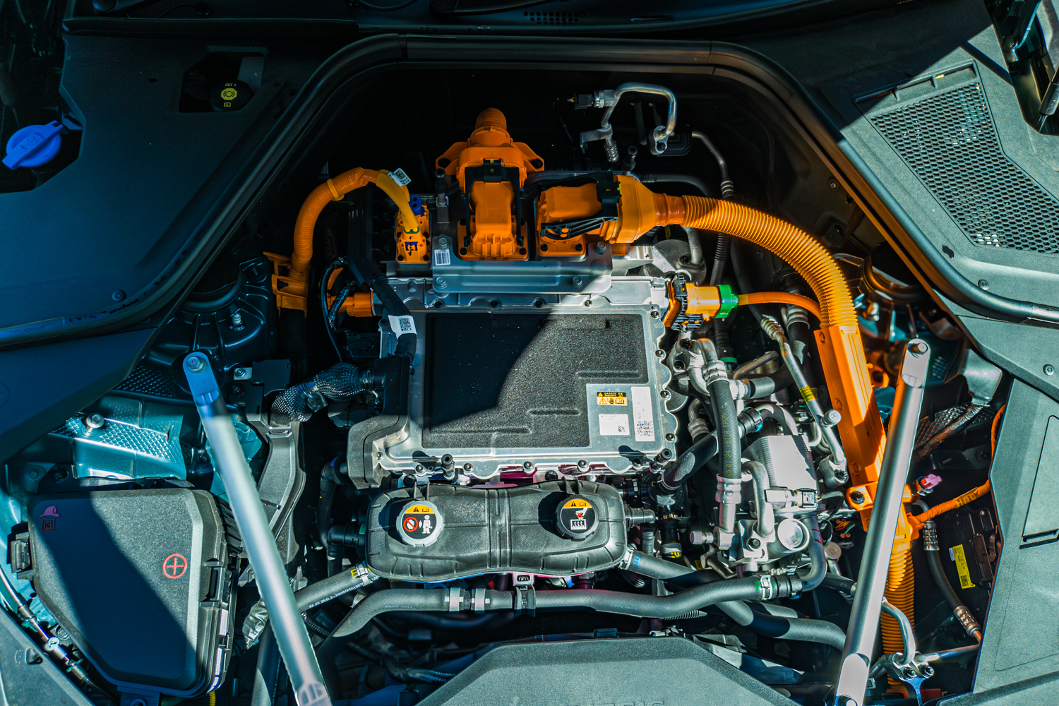 2026 Genesis G80 Electrified open motor bay showing electric drivetrain and orange high-voltage cables