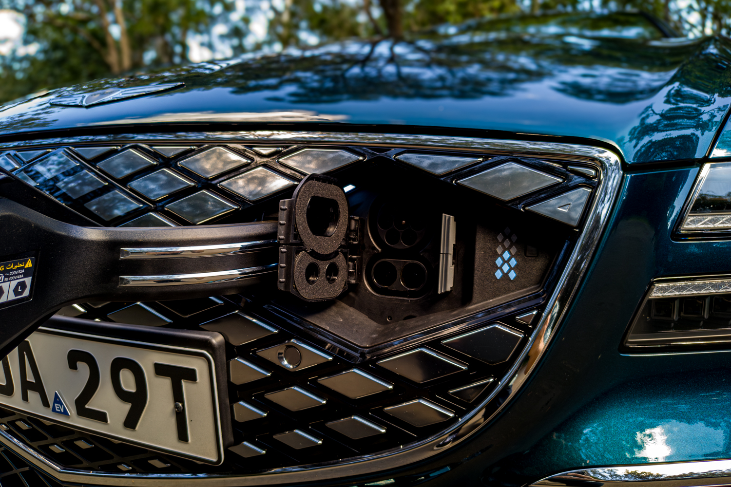 2026 Genesis G80 Electrified front CCS2 charging port open inside the crest grille