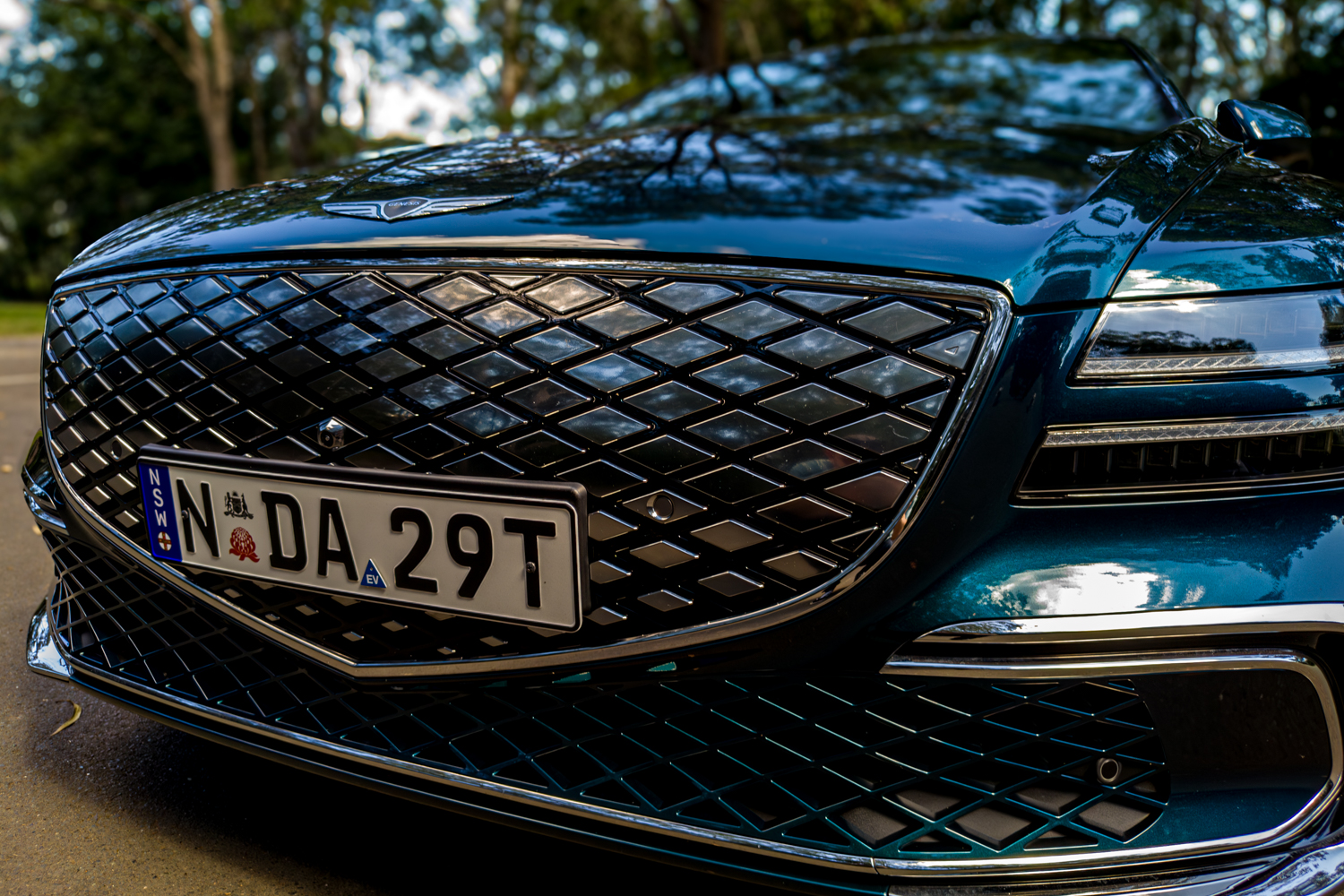 2026 Genesis G80 Electrified Matira Blue front grille and lower bumper wide angle