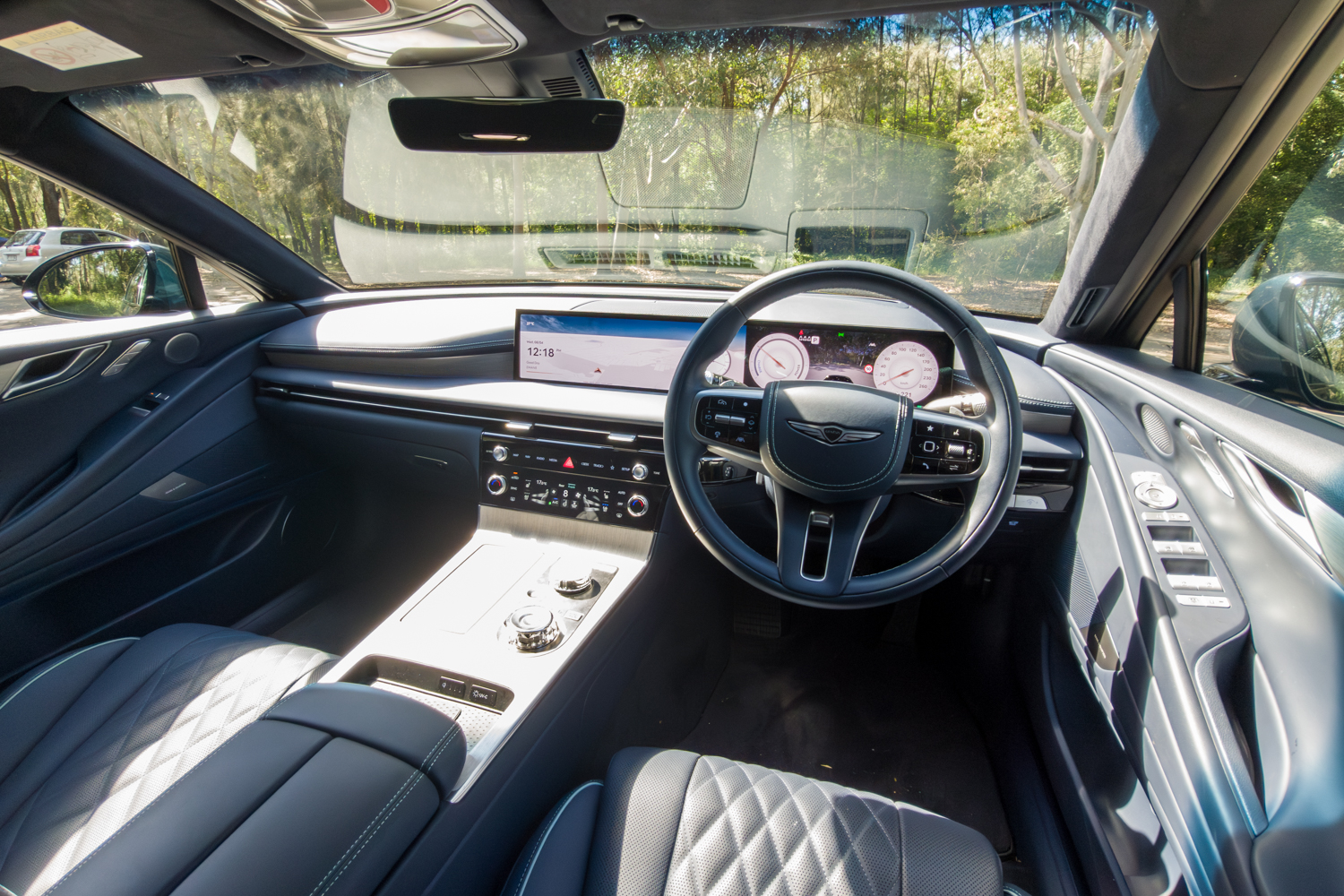 2026 Genesis G80 Electrified right-hand-drive interior cockpit showing steering wheel infotainment and centre console