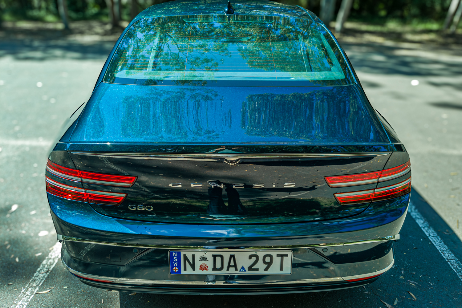 2026 Genesis G80 Electrified Matira Blue rear overhead elevated view showing roofline and tail lights