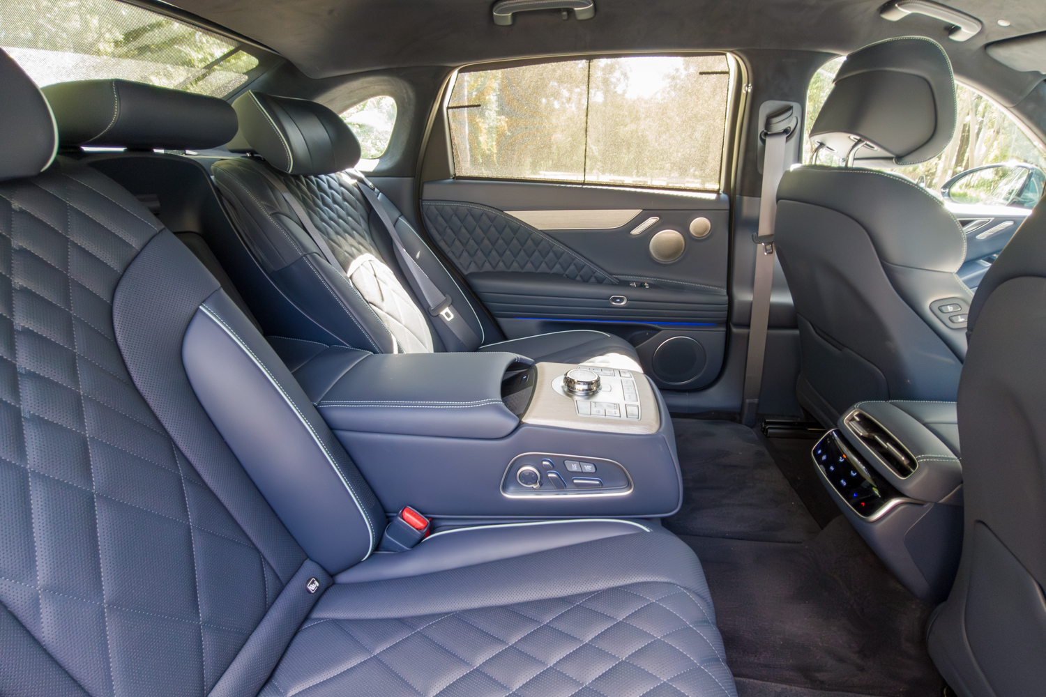 2026 Genesis G80 Electrified rear seats from driver side right showing quilted leather and armrest controls