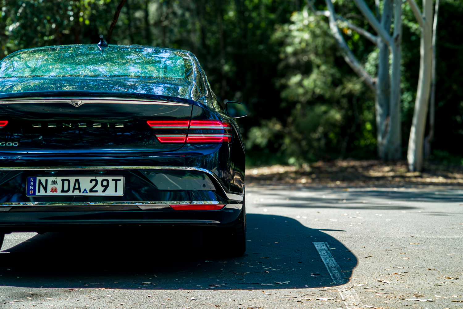2026 Genesis G80 Electrified Matira Blue straight-on rear view showing tail lights and Genesis badging