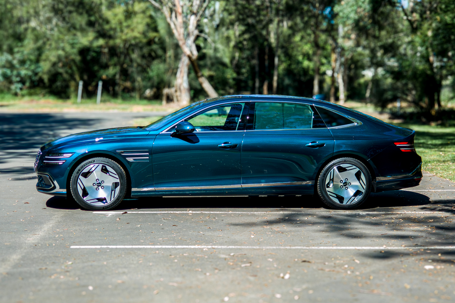 2026 Genesis G80 Electrified Matira Blue full side profile from driver side right showing fastback silhouette