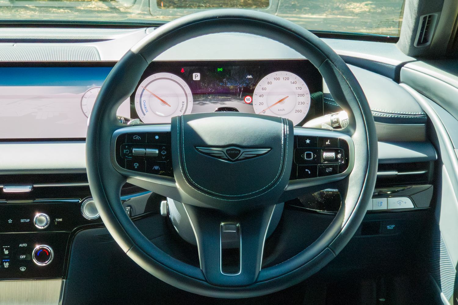 2026 Genesis G80 Electrified right-hand-drive steering wheel showing Genesis badge and digital instrument cluster