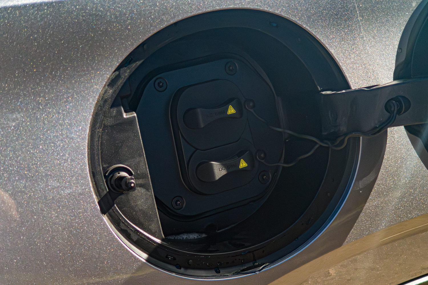 Open charging flap on the grey 2026 GWM Haval H6 PHEV with AC and DC port covers