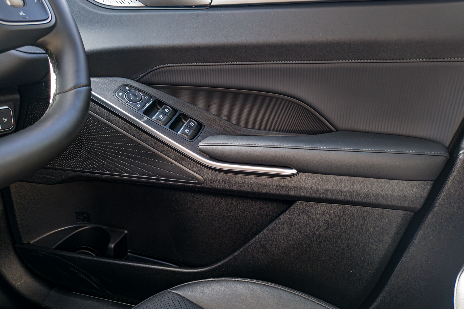 Driver's door panel of the 2026 GWM Haval H6 PHEV with window switches and armrest