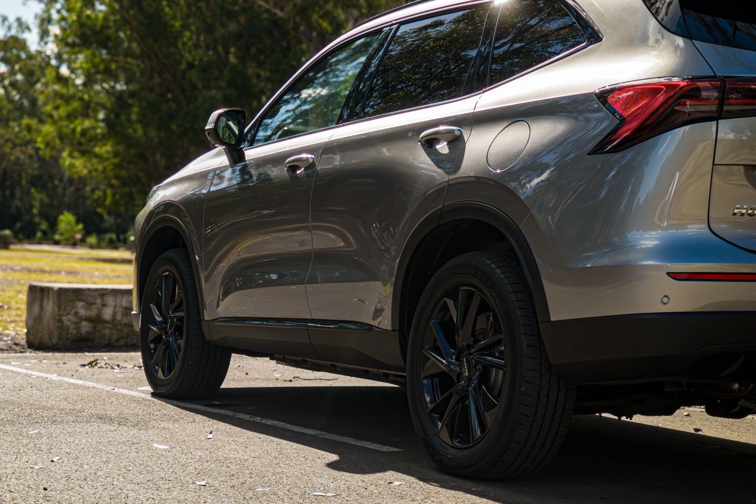 Side body detail of the grey 2026 GWM Haval H6 PHEV showing door handles and rear wheel