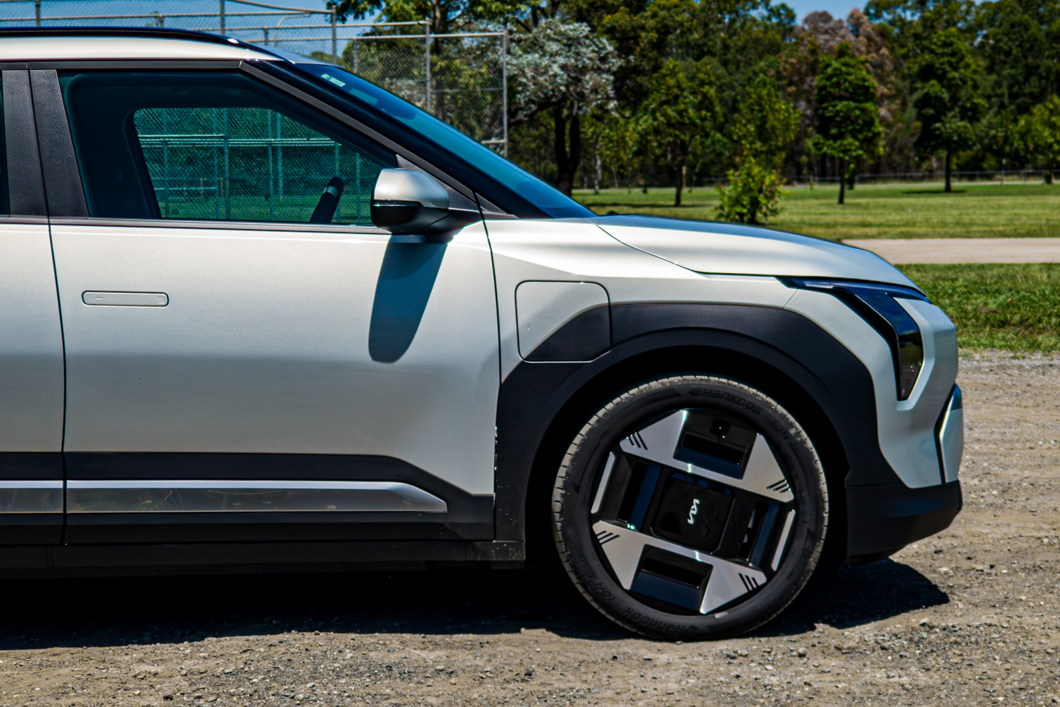 Driver's-side front detail of the 2026 Kia EV3 Earth Long Range showing wing mirror, front door and wheel