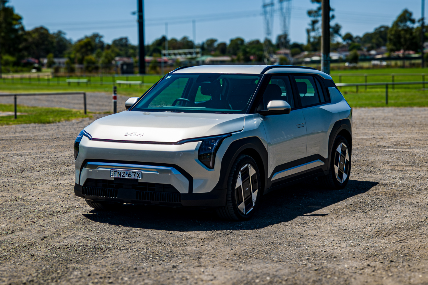Passenger's-side front three-quarter of the 2026 Kia EV3 Earth Long Range on gravel