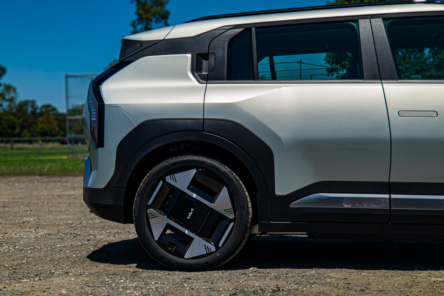 Low close-up of the front wheel, 19-inch alloy and black wheel-arch cladding on the 2026 Kia EV3 Earth Long Range