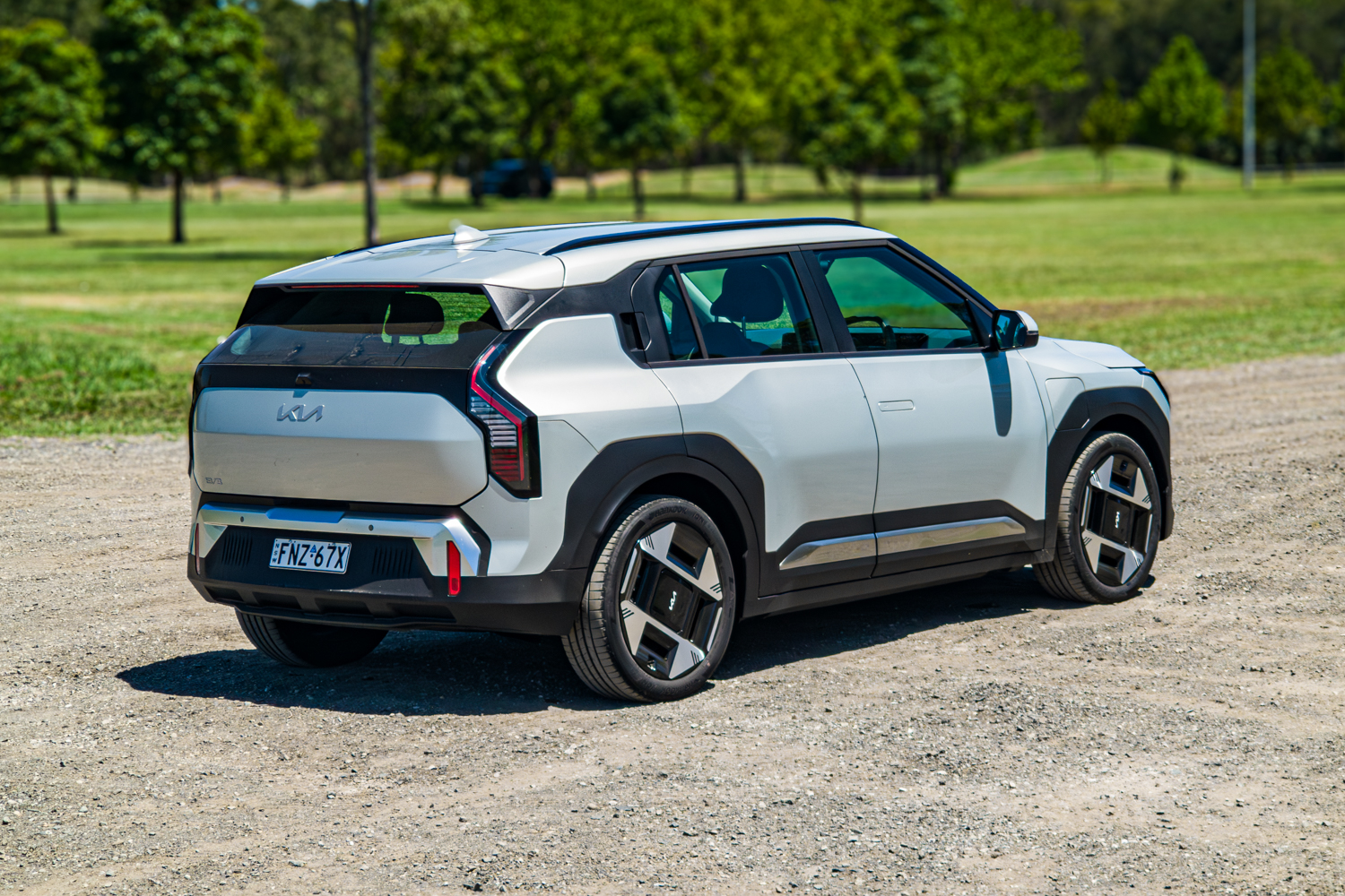 Driver's-side rear three-quarter angle of the 2026 Kia EV3 Earth Long Range on gravel