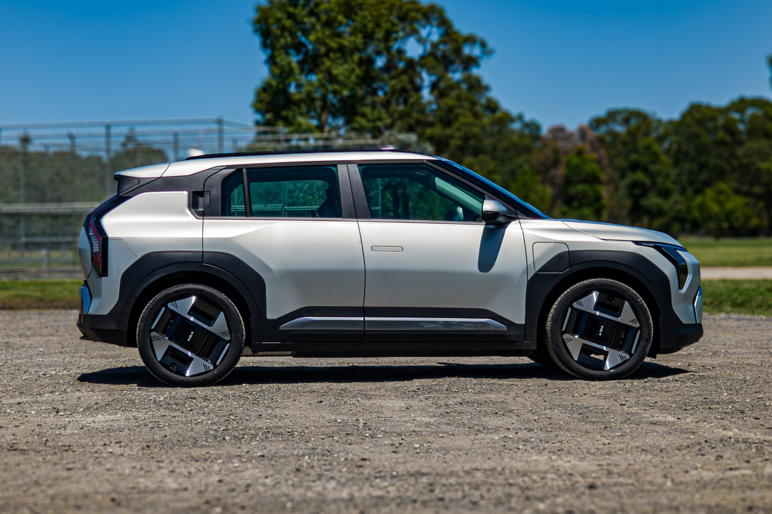 Driver's-side profile of the 2026 Kia EV3 Earth Long Range parked on gravel