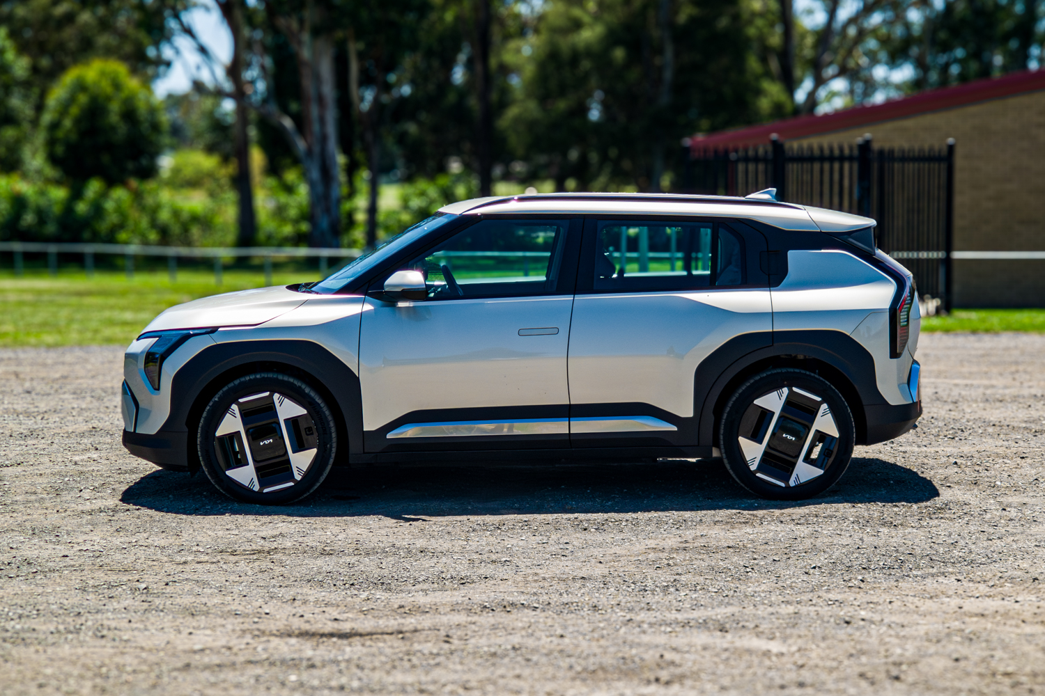 Passenger's-side profile view of the 2026 Kia EV3 Earth Long Range parked on gravel