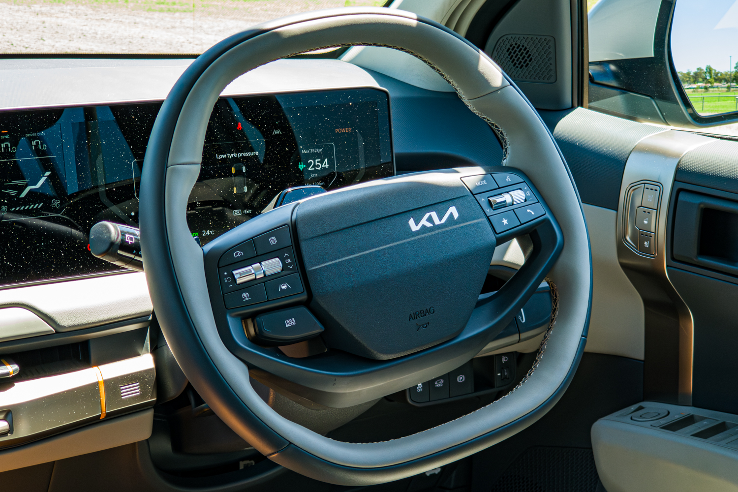 Close-up of the steering wheel and digital driver cluster in the 2026 Kia EV3 Earth Long Range