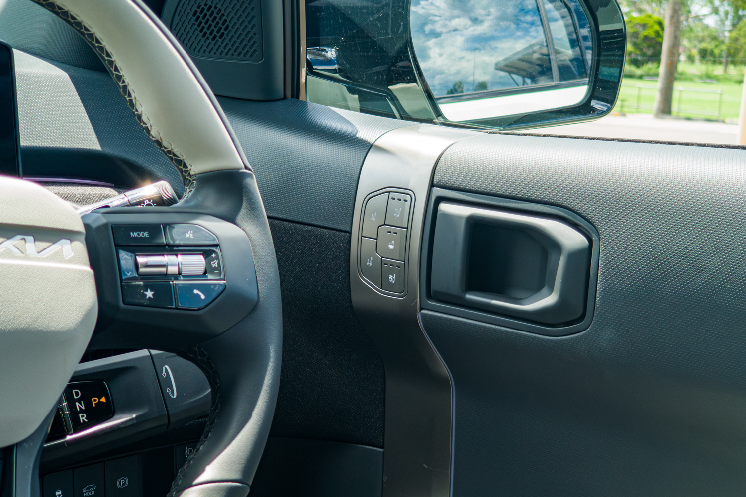 Driver door handle and window controls inside the 2026 Kia EV3 GT-Line