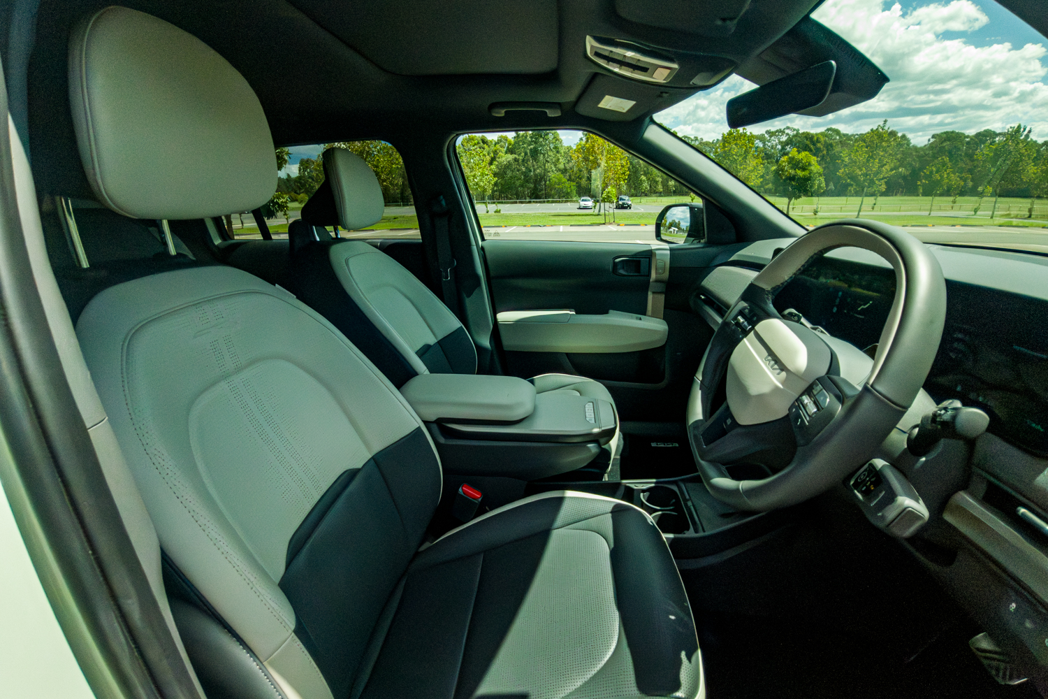 Front seats of the 2026 Kia EV3 GT-Line showing two-tone grey synthetic leather