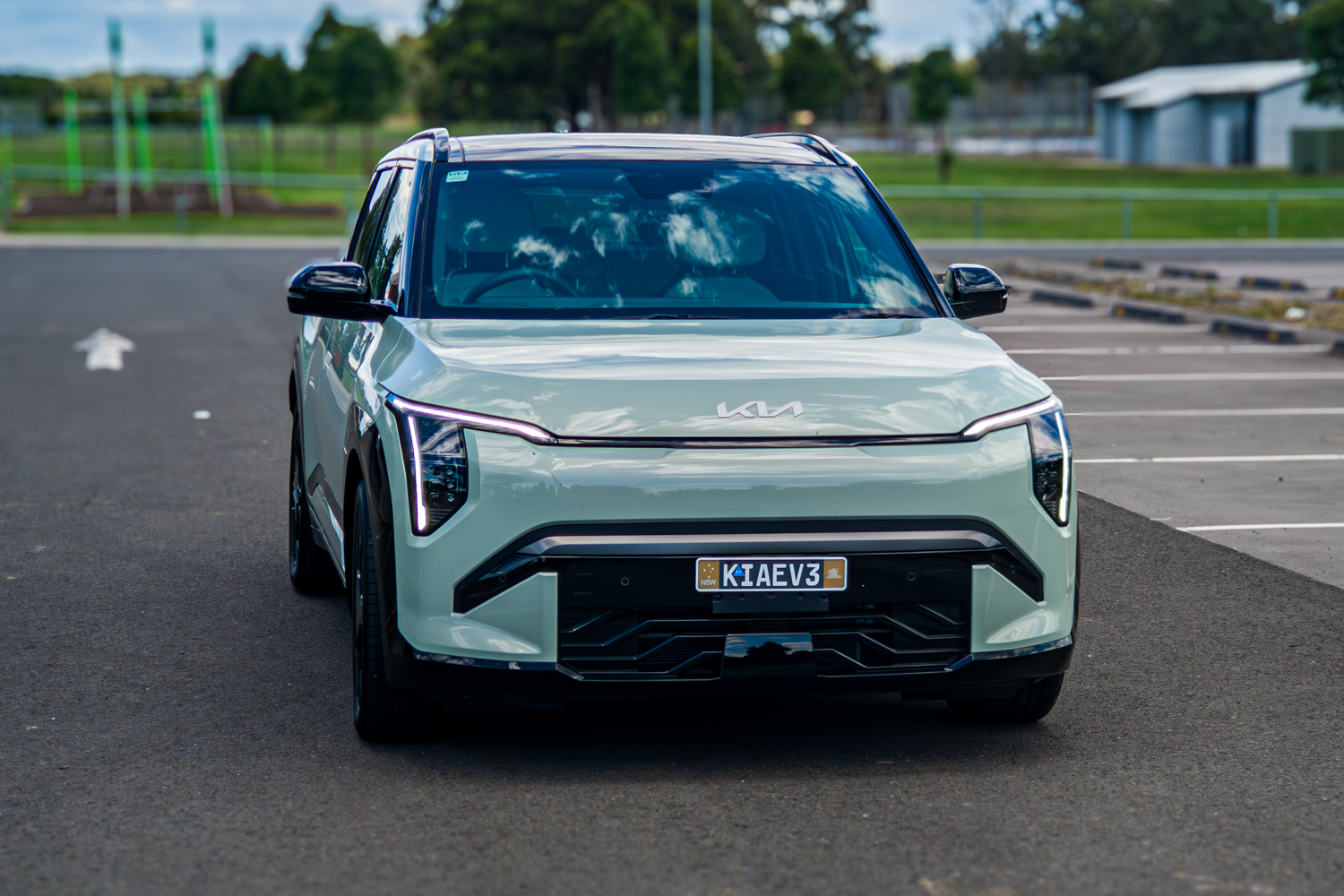 Wide front view of the 2026 Kia EV3 GT-Line in a green park setting