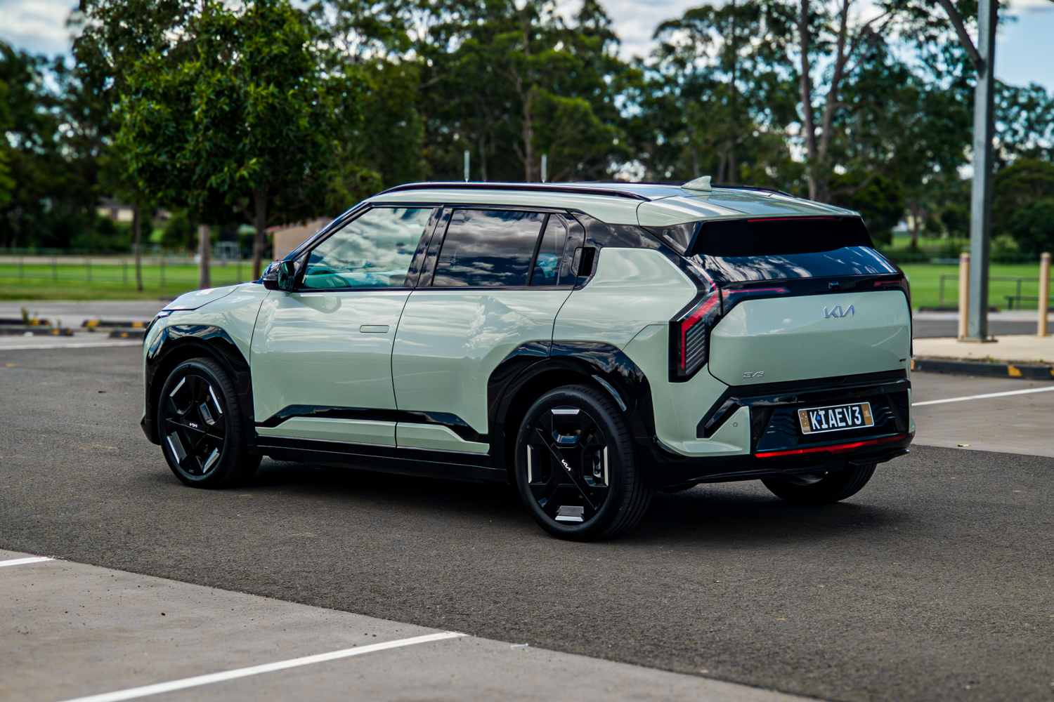 Rear right three-quarter view of the 2026 Kia EV3 GT-Line with trees background