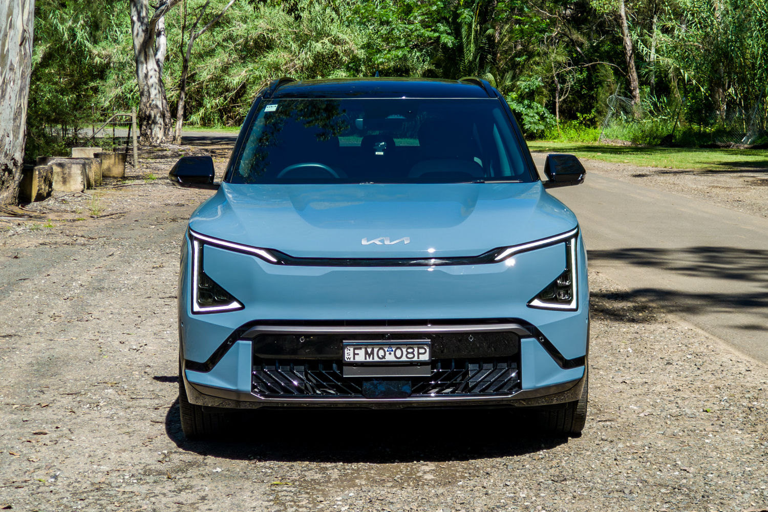 Head-on front view of the blue Kia EV5 GT-Line showing its vertical LED light signature