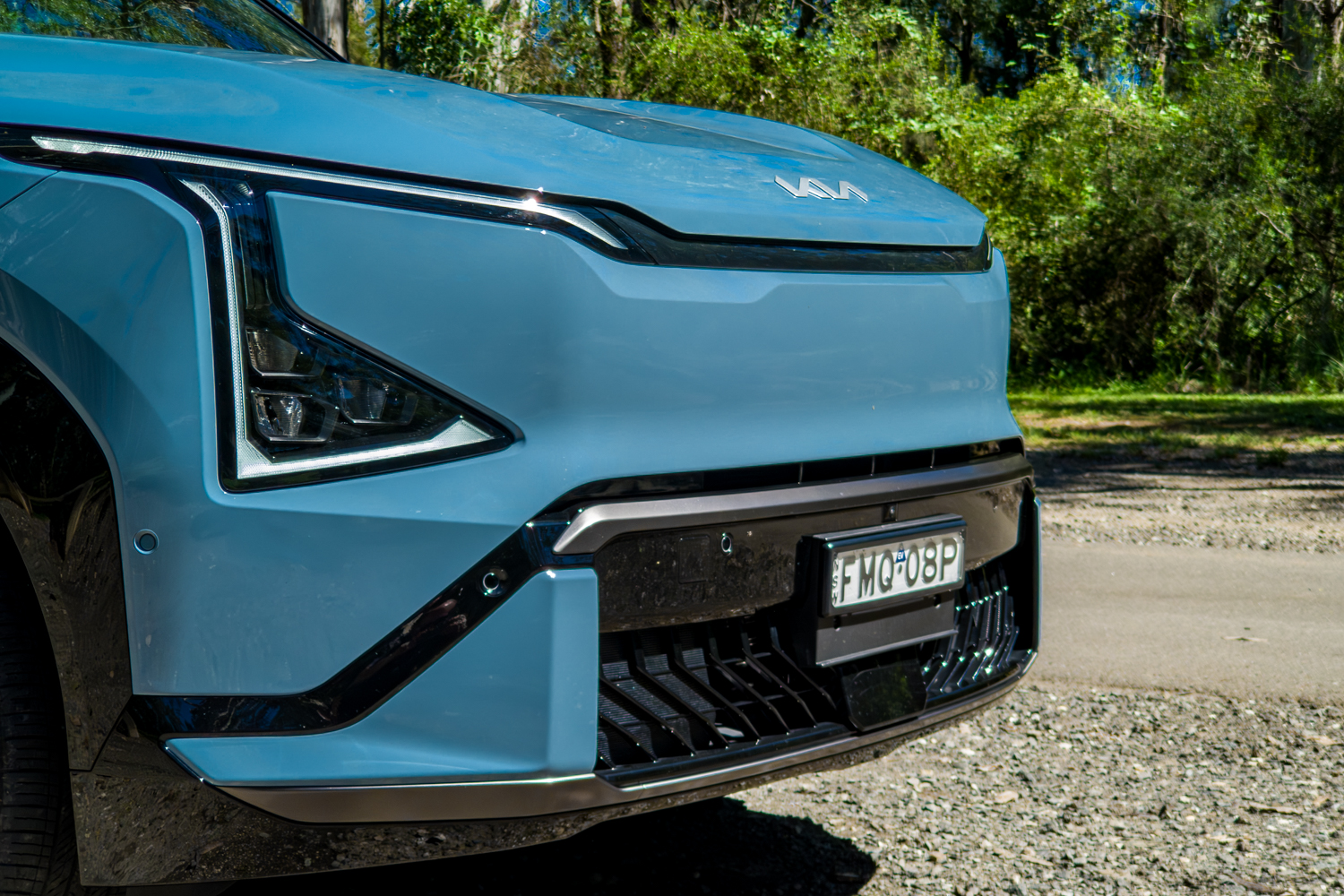 Close-up of the Kia EV5 GT-Line LED headlight, Kia logo and lower intake