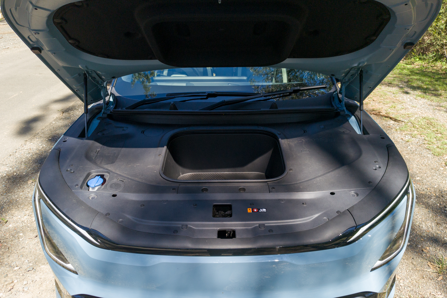 Open front boot or frunk of the Kia EV5 GT-Line showing the underbonnet storage tub