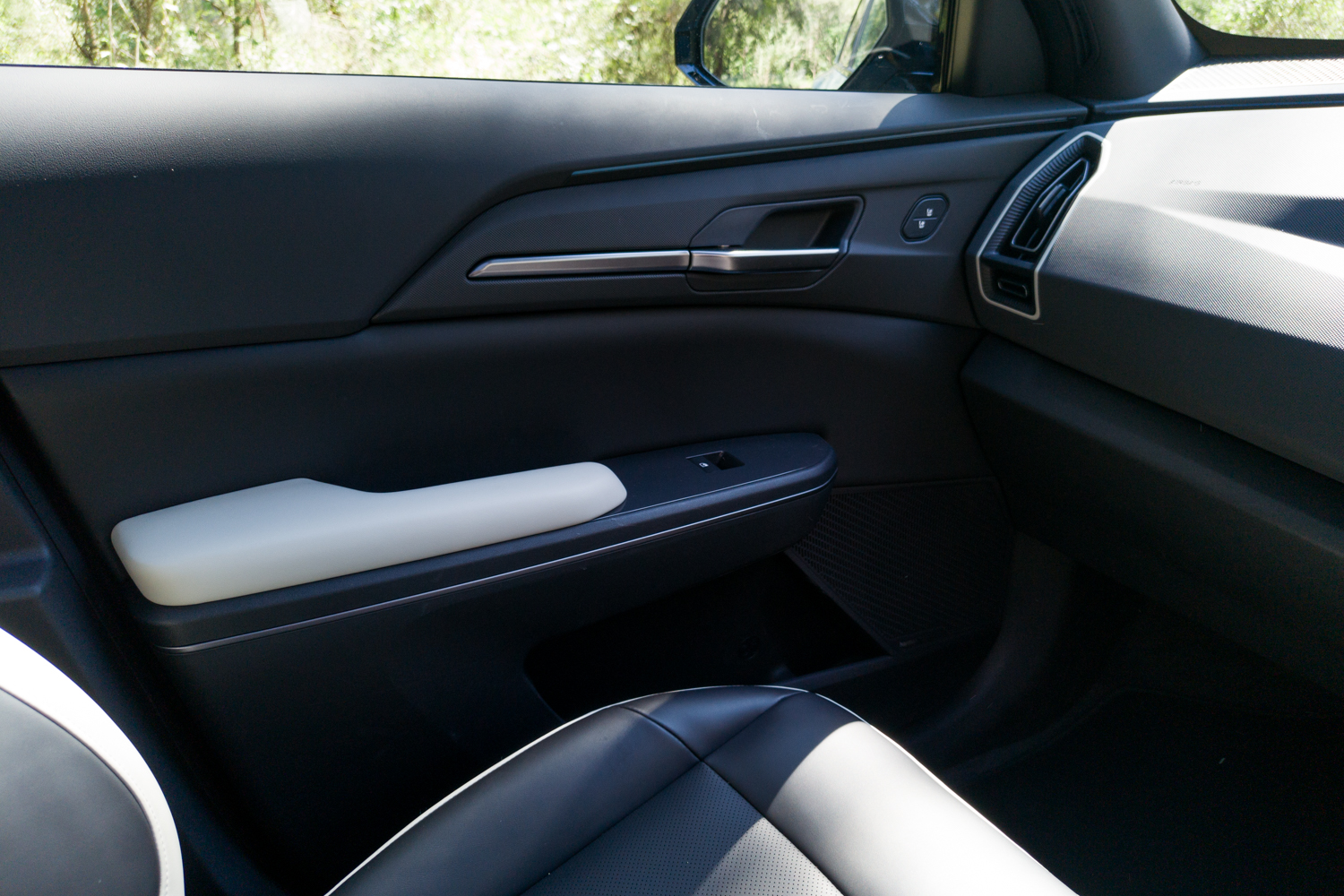 Front passenger door card of the Kia EV5 GT-Line with padded armrest and window switch
