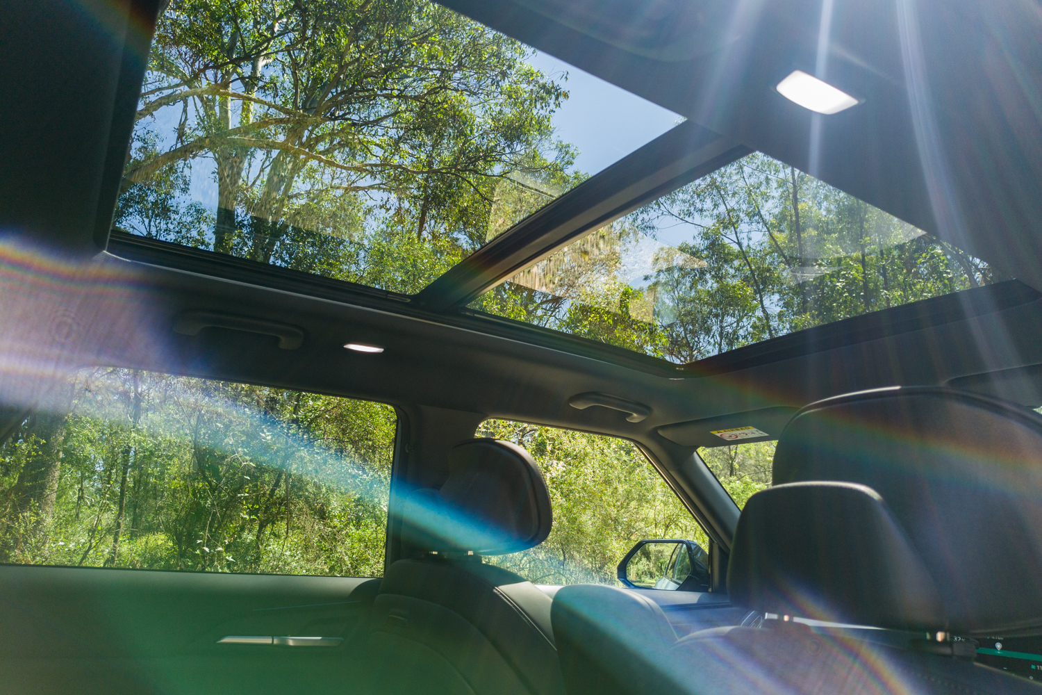 Interior view looking up at the Kia EV5 GT-Line panoramic glass sunroof
