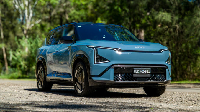 Wide low front three-quarter of the blue Kia EV5 GT-Line showing its stance