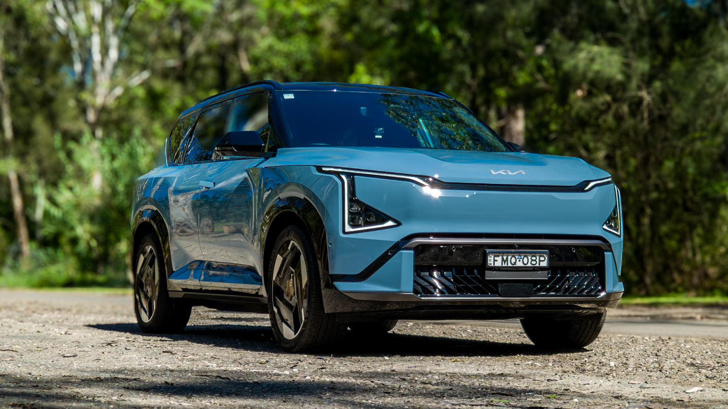 Wide low front three-quarter of the blue Kia EV5 GT-Line showing its stance