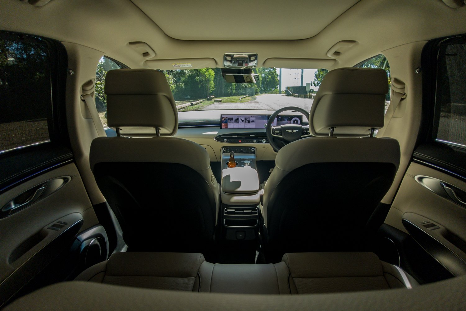 Wide-angle view forward from the rear seat of the 2026 Genesis GV70 2.5T Advanced showing the front seats and dashboard