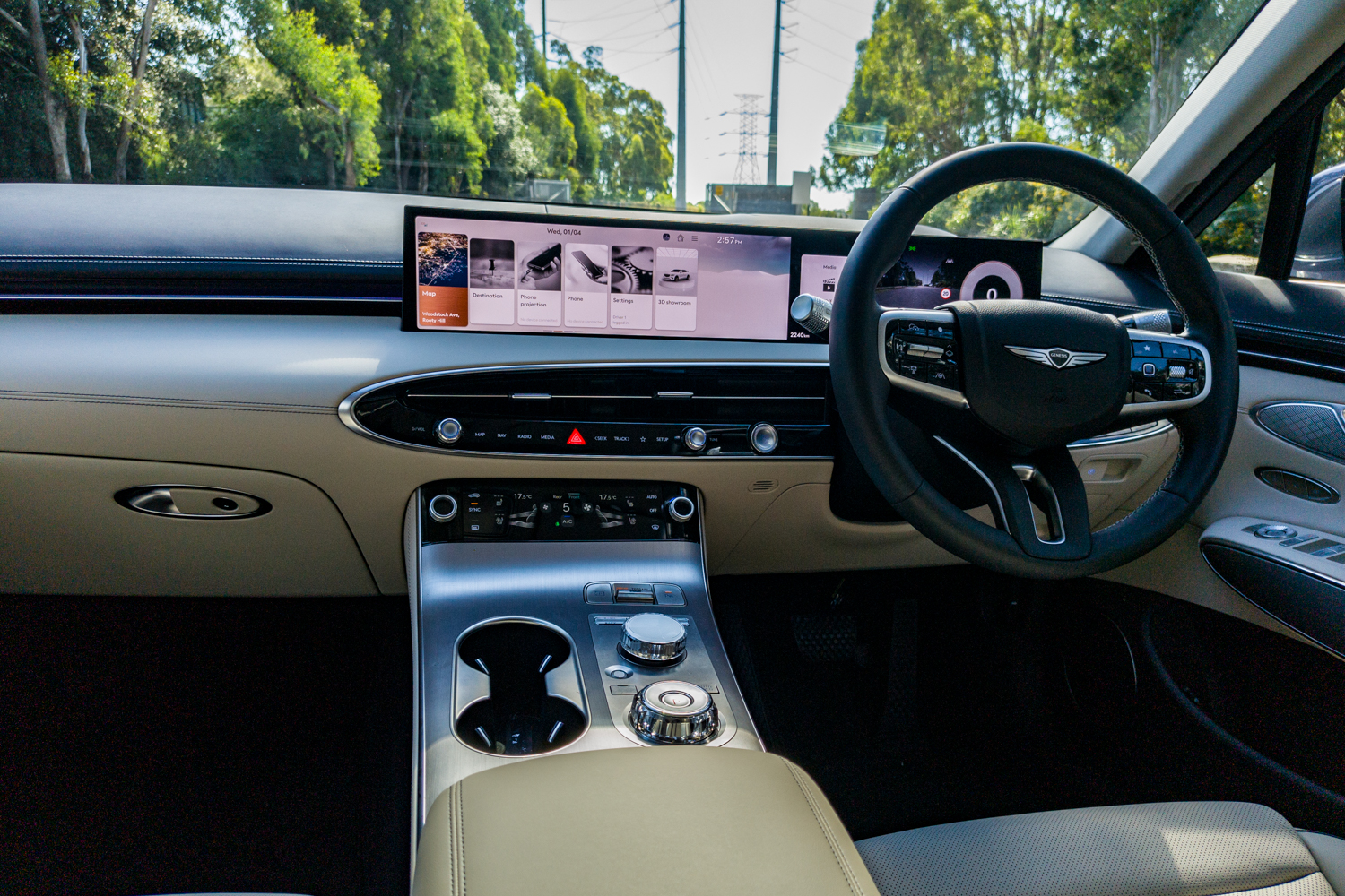 Dashboard of the 2026 Genesis GV70 2.5T Advanced showing the 27-inch OLED display, oval vent bar and twin rotary dials