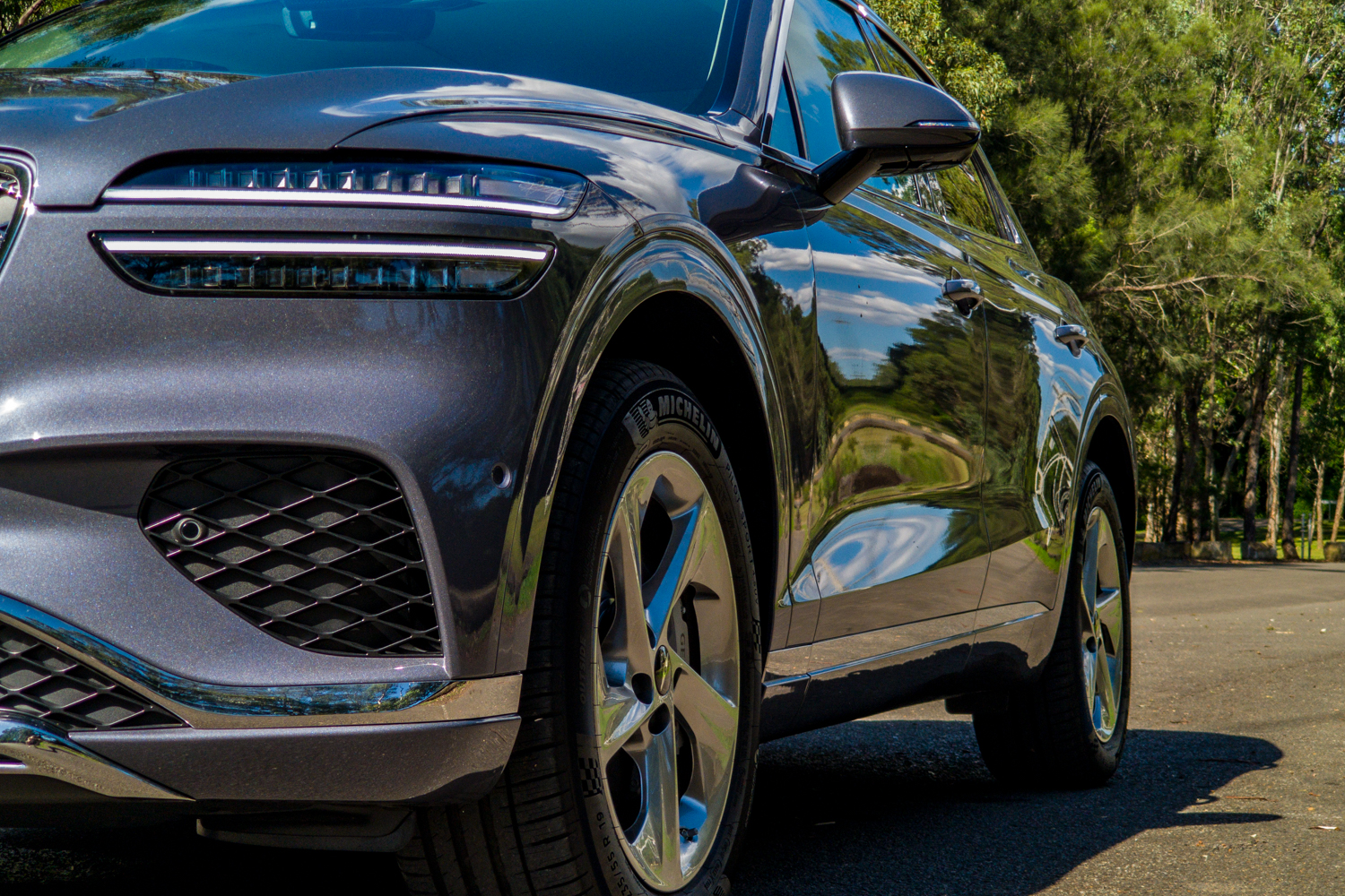 Low driver's-side front corner of the 2026 Genesis GV70 2.5T Advanced showing the headlight, intake and alloy wheel