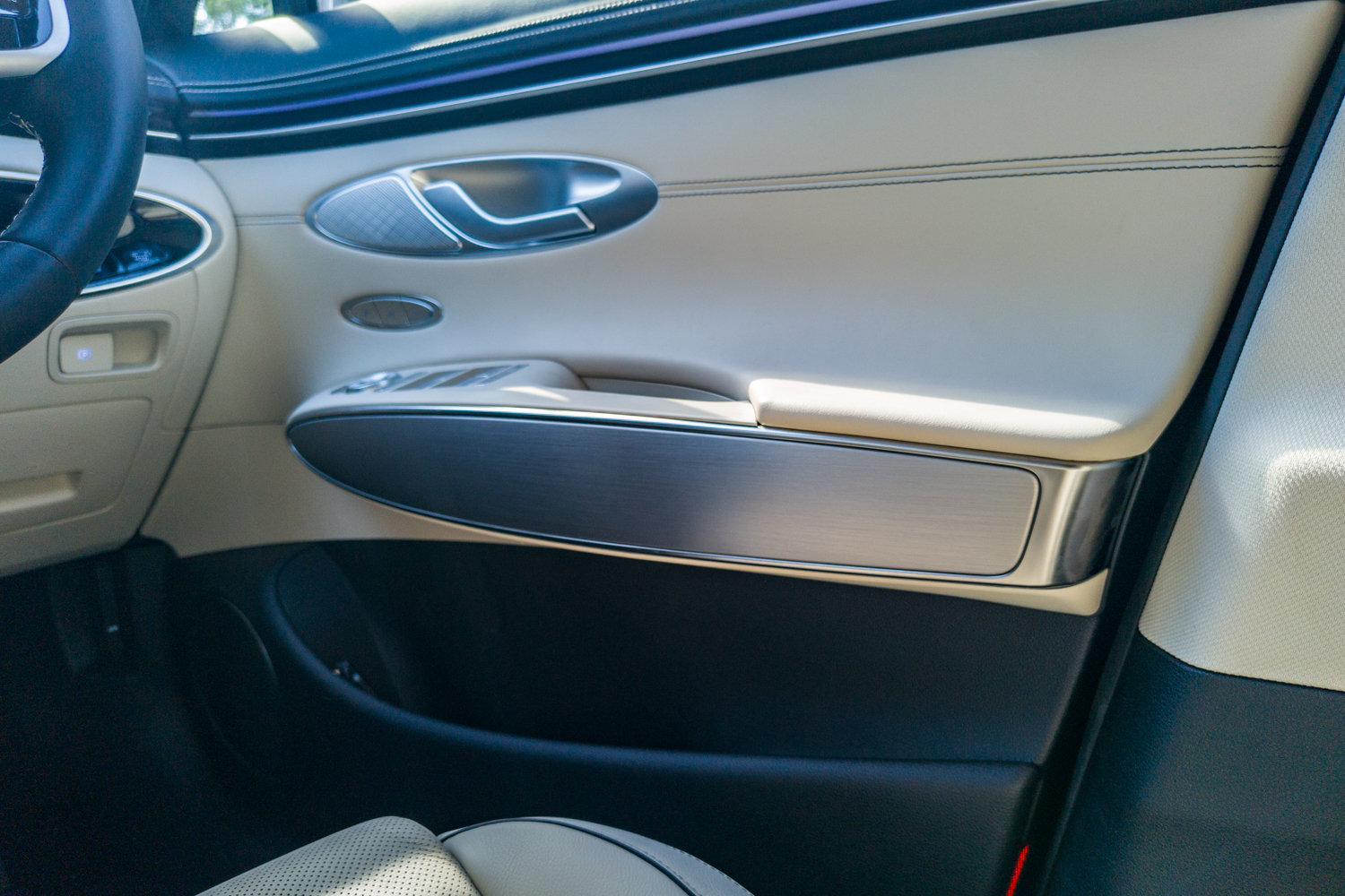Driver's door trim of the 2026 Genesis GV70 2.5T Advanced in cream leather with brushed aluminium and oval handle