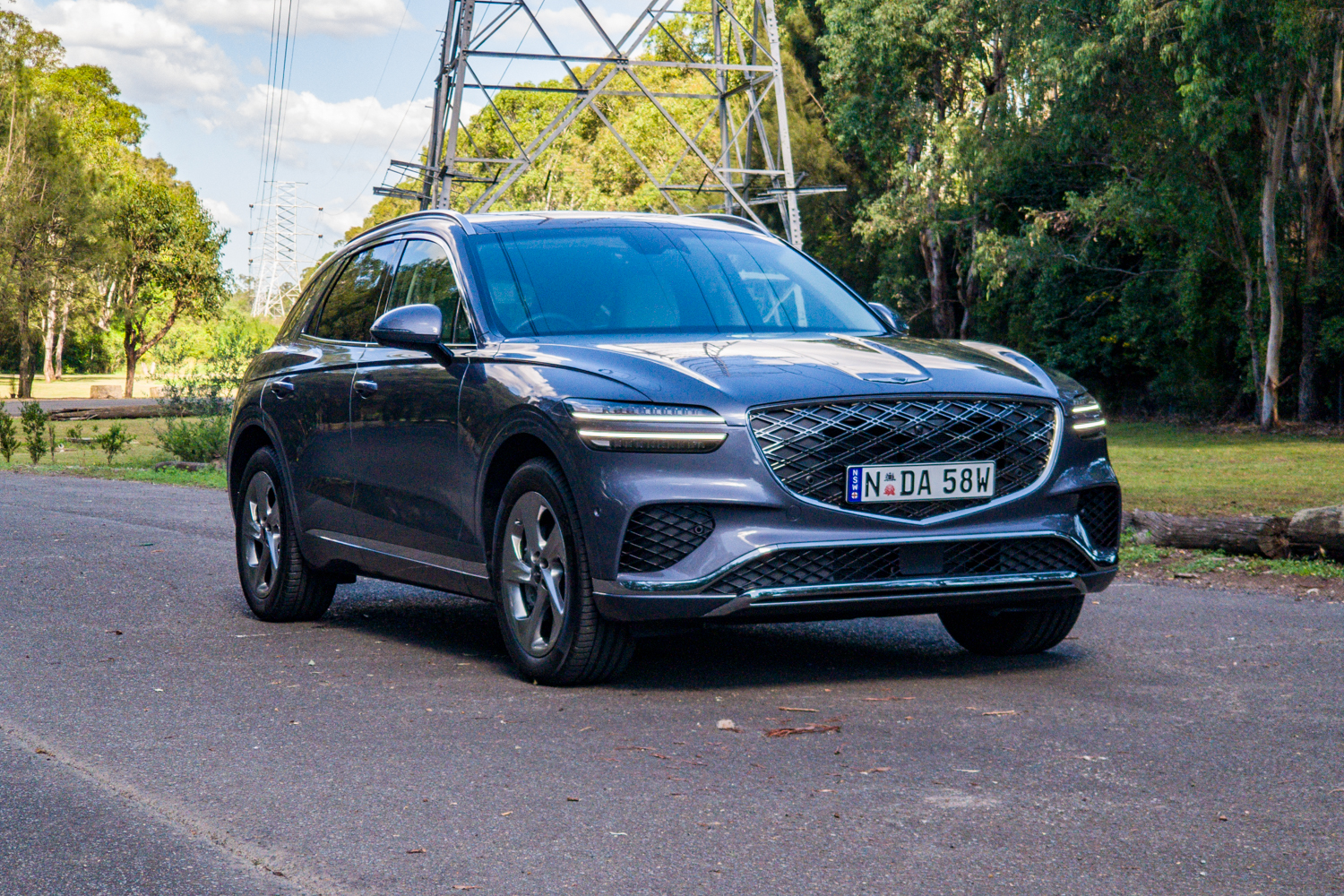 Close front three-quarter of the 2026 Genesis GV70 2.5T Advanced showing the grille and two-line headlights