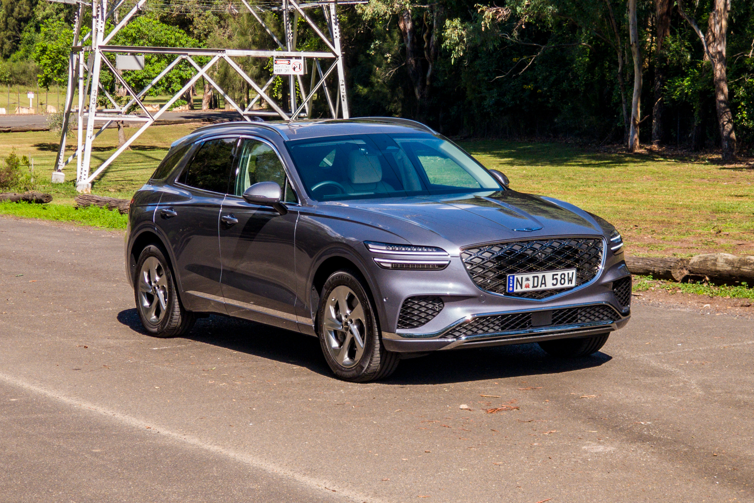 Front three-quarter view of the 2026 Genesis GV70 2.5T Advanced from the driver's side under a power pylon