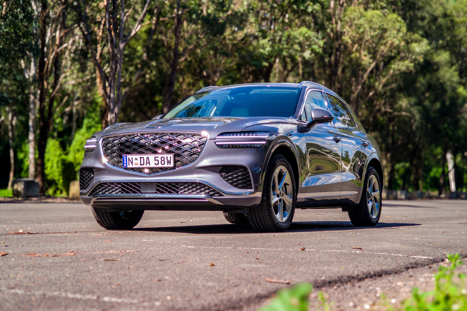 Low front three-quarter view of the 2026 Genesis GV70 2.5T Advanced in metallic grey-blue on 19-inch wheels
