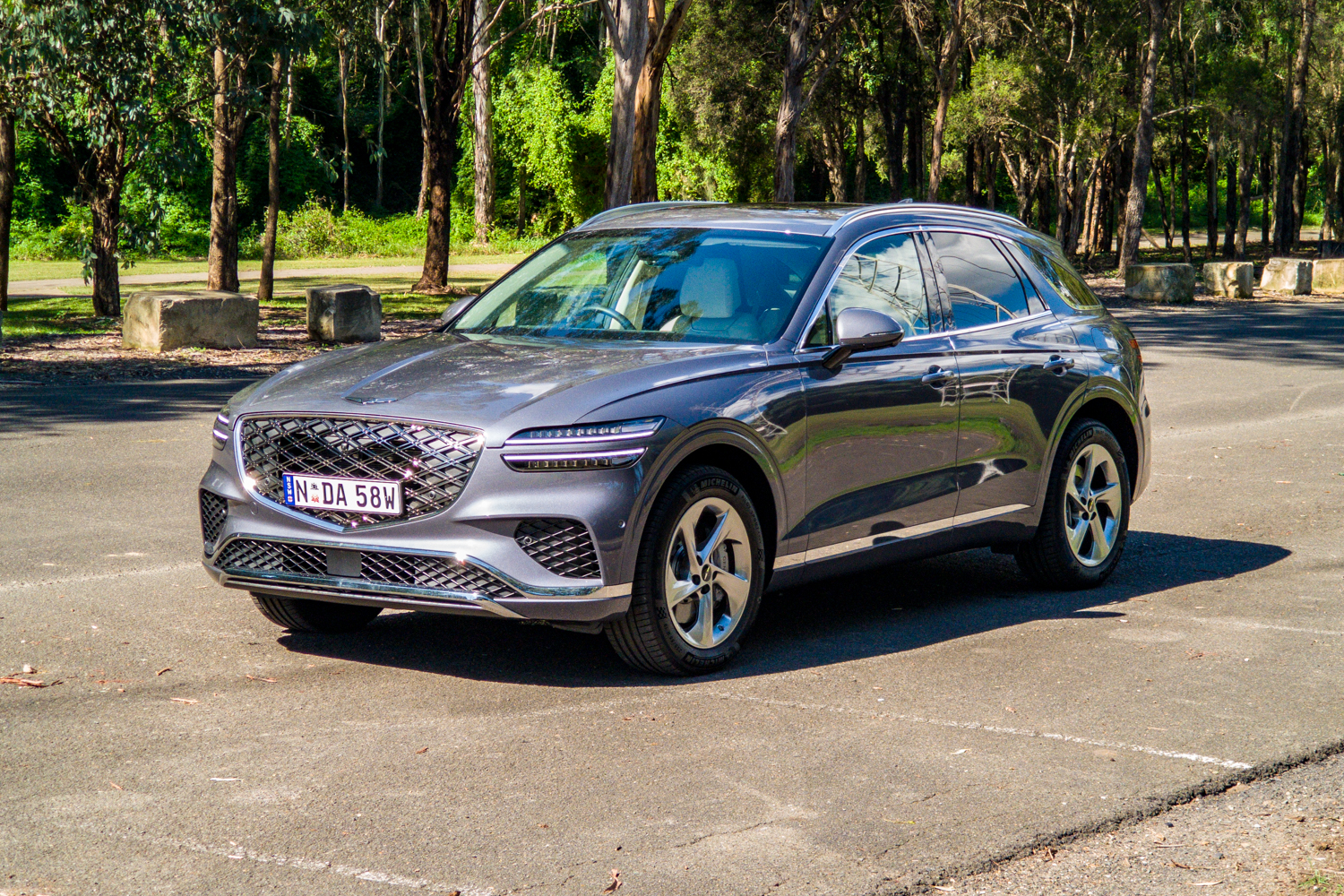 Passenger's-side front three-quarter of the 2026 Genesis GV70 2.5T Advanced in a tree-lined car park