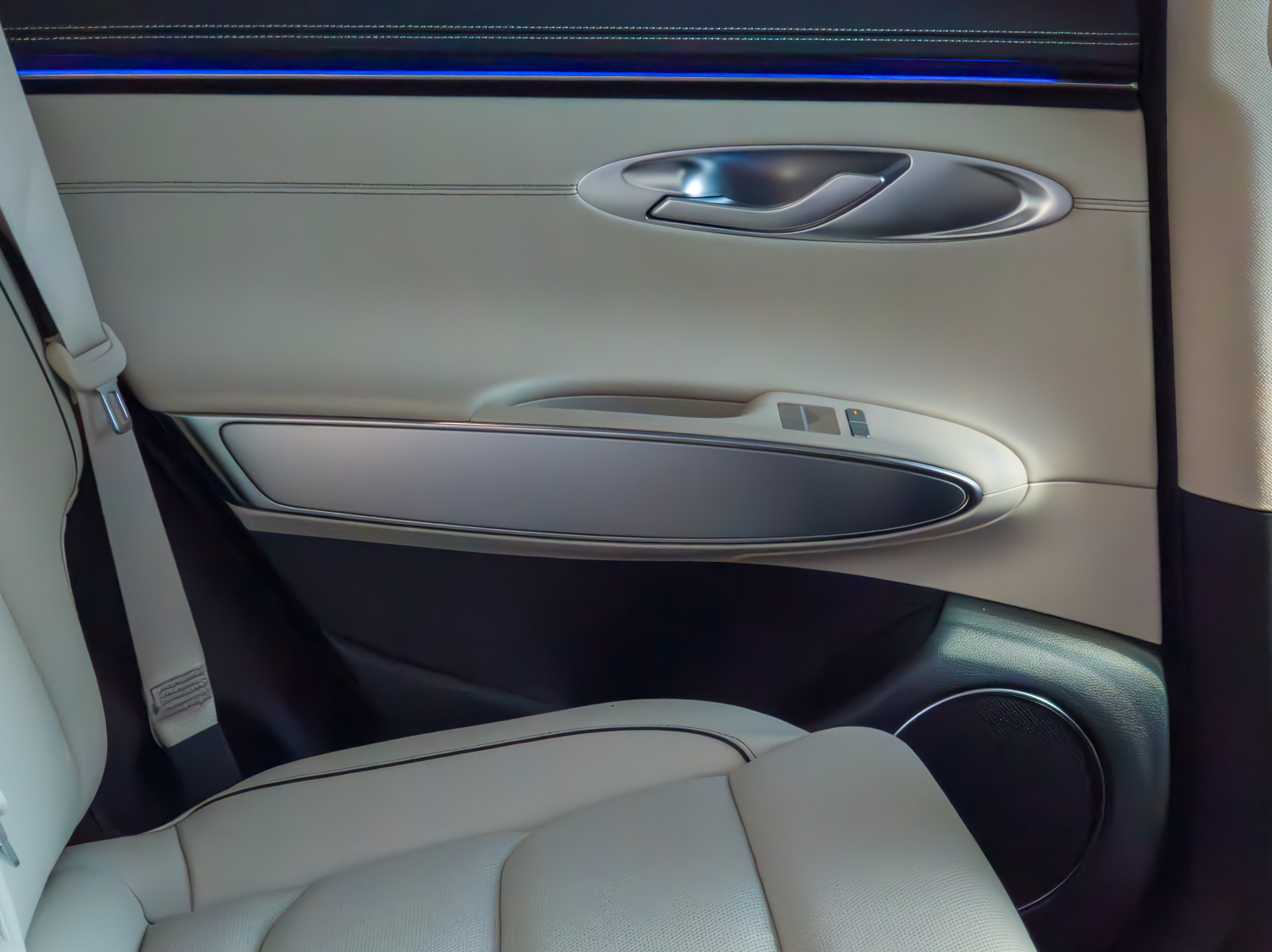 Rear door trim of the 2026 Genesis GV70 2.5T Advanced in cream leather with brushed aluminium and blue ambient lighting
